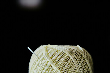Needle  and yellow thread with black background Close up Needle  and yellow thread. Details of a thread and it can be observed its winding geometry