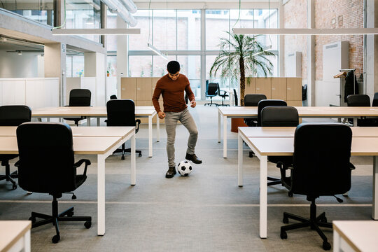 Young Entrepreneur Playing With Soccer Ball In Office