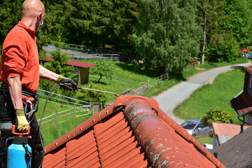 Behandlung eines Ziegeldachs mit Drucksprüher und Algizid gegen Algen-, Flechten- und Moos-Bewuchs