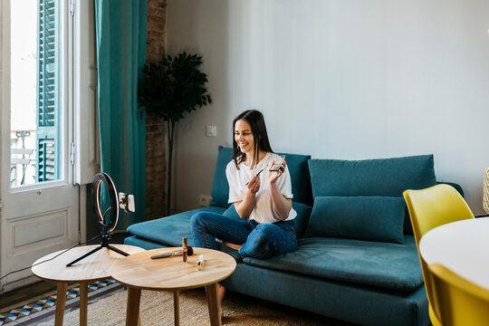 Female influencer filming tutorial on make-up at home