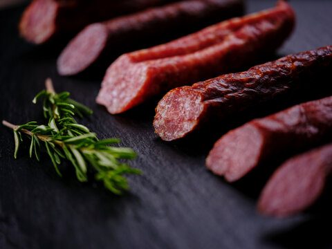 Sausage with rosemary on black slate stone slab