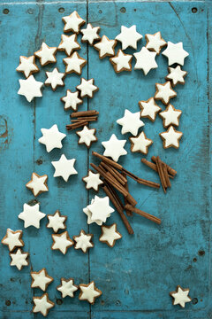 Christmas cinnamon star shaped cookies and cinnamon on blue rustic wooden background