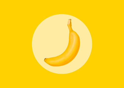 Studio shot of single banana lying against yellow background
