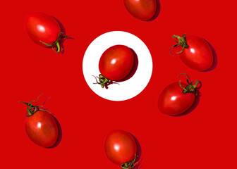 Studio shot of cherry tomatoes lying against red background