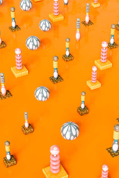 Three dimensional render of abstract board game pieces standing against orange background