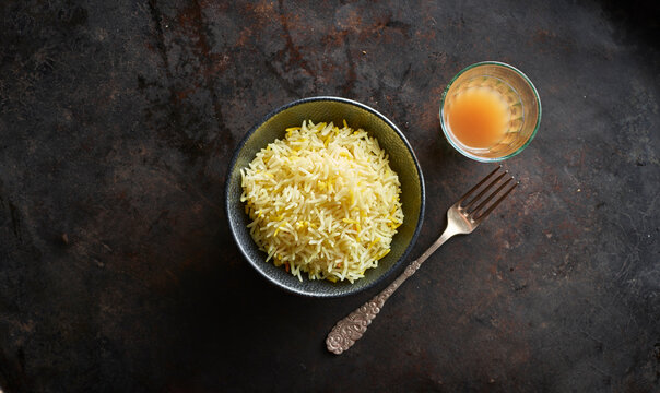 Studio shot of bowl of basmati rice. single fork and glass of chai tea
