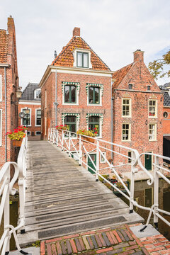 Netherlands, Groningen Province, Appingedam, Footbridge over Damsterdiep canal with brick townhouses in background