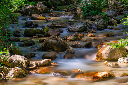 Long exposure of river flowing between rocks in Monte Cucco Park, Umbria, Italy