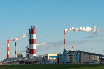Industrial zone. A large enterprise for the production of chemical and mineral fertilizers and pesticides. White smoke or steam escapes from a large chimney.