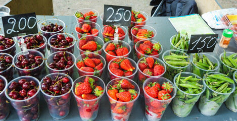 cups with berries for sale in the park, cherries, peas, strawberries, the price of berries, street...