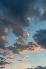 blue sky with dark clouds illuminated by the evening setting sun as a natural background