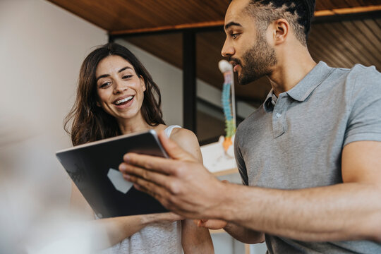 Male physiotherapist and female patient discussing over digital tablet in practice