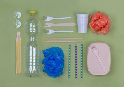Studio shot of arrangement of plastic items including forks, bottle, bags and drinking straws
