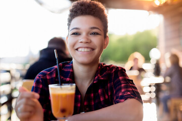 beautiful and happy african american woman with short hair in a summer cafe