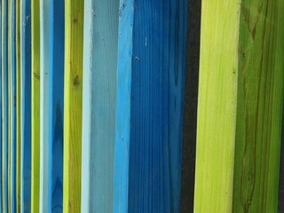 The boards are painted with bright colors.  Several fence boards are painted with beautiful paints