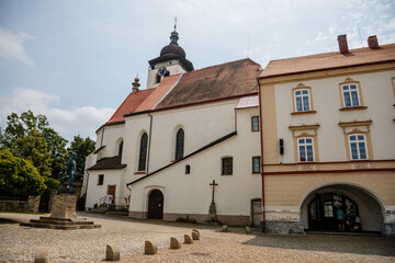 Fototapeta premium Main Husovo Square, colorful houses on sunny day, renaissance and baroque historical buildings, arcade, Church of the Holy Trinity, medieval town Nove mesto nad Metuji, Czech Republic