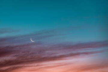Crescent moon glowing against sky at dusk