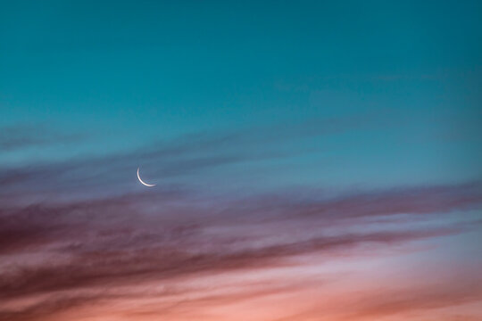 Fototapeta Crescent moon glowing against sky at dusk