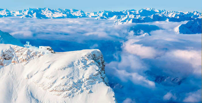 Motor home parked on edge of Zugspitze peak with fog shrouded valley in background
