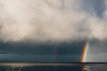 gray clouds with rainbow over the sea ocean  - Powered by Adobe