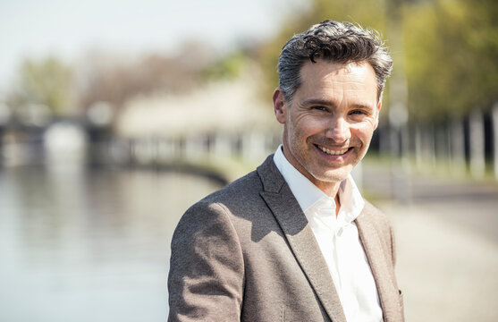 Mature businessman smiling during sunny day