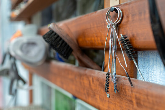 Brush and work tools hanging on wood at workshop