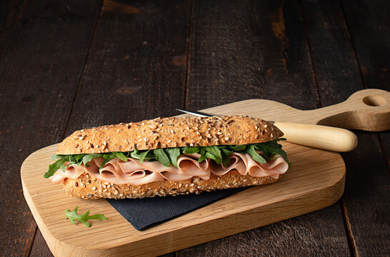 Mortadella sandwich on dark wooden table