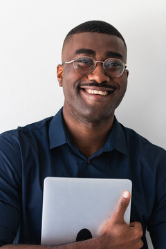 Smiling Black Guy With Laptop Near White Wall