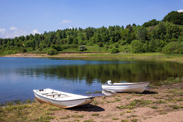 Naklejka na ściany i meble Two boats on the lake shore. Calm, relax scenery. Vlasina lake, Eastern Serbia