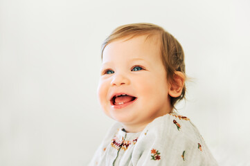 Close up portrait of adorable toddler girl with blue eyes on white background