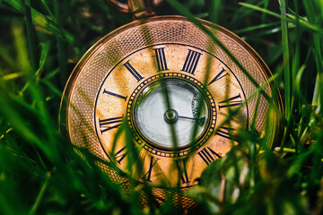 Selective focus shot of a greek numeral clock on the green grass