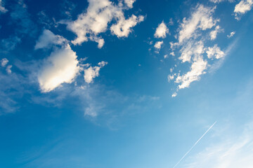 White fluffy clouds on the blue sky. View from the plane.