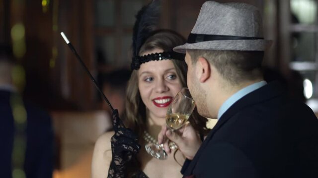 Vintage retro Great gatsby young couple taking, dancing and drinking champagne on a throwback retro roaring twenties party