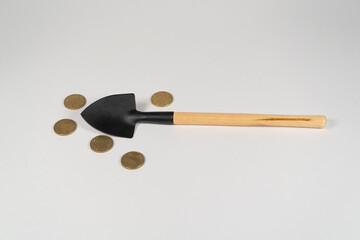 A shovel and small money next to it. Treasure search.