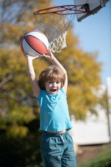 Kid playing basketball with basket ball. Active kids lifestyle.