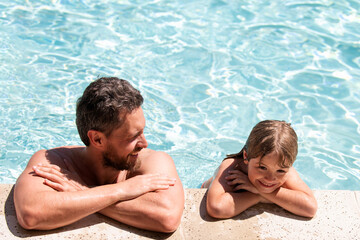 Father and son in pool. Summer resort. Pool party. Boy with dad in swimming pool. Active lifestyle concept.