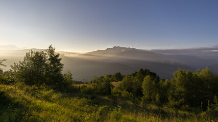 Fototapeta premium panorama of peaceful morning with sunrise over french alps with meadow in foreground
