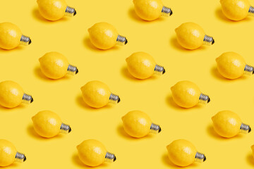 Pattern with fresh lemons as bulbs isolated on a yellow background. Creative food recipe idea. Abstract and surreal fruit health diet concept. Flat lay, top view.