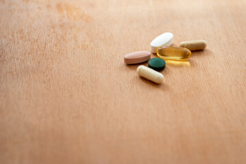 Fototapeta na wymiar Top view of supplement pills on a wooden table