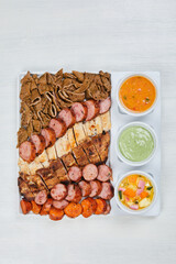 variety of grilled meats and chicken with mayonnaise and sauces