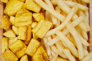 fried green plantain with french fries close up view