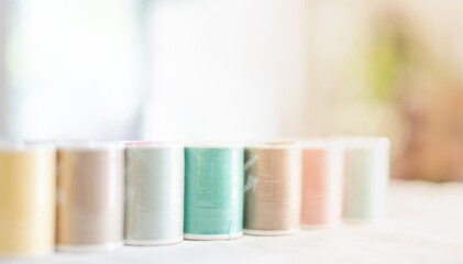 The pastel color embroidery thread spool using in the garment industry, the row of multicolored...