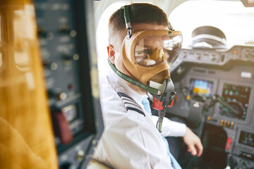Male pilot wear air mask in cockpit of airplane © Ivan