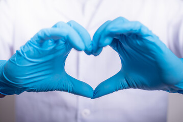 Close up of Doctor hands in gloves making shape of heart, Medicine and Healthcare Concept.