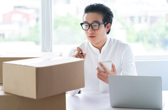 Asian businessman packing goods to send to customers
