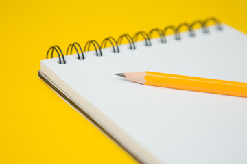Selective focus of Notebook, pencil on a yellow background  and copy space