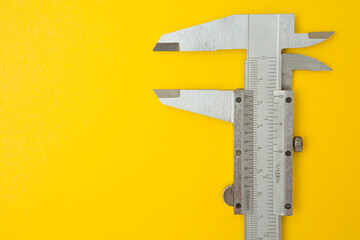 Top view of iron Vernier Calipers on yellow background  and copy space