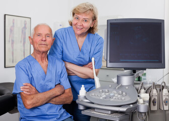 Obraz premium Portrait of senior man doctor and woman nurse in cabinet of ultrasound test