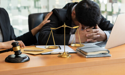 Consulting of business women and male lawyers or judges counselors. Legal services concept with judge's hammer and golden scales with laptop on table.
