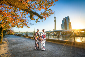 Two asian women walking acros  Sumida river canal in Asakusa,Tokyo. Japan